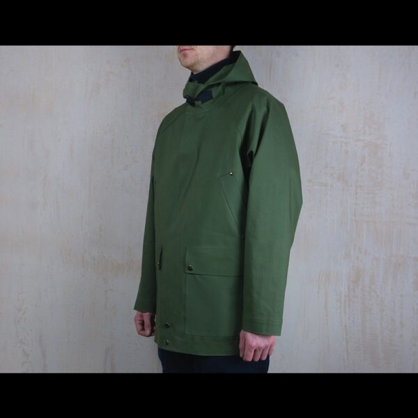 Side-View-Of-Model-Wearing-Green-Waterproof-Rain-Parka-By-Rainford-Apparel