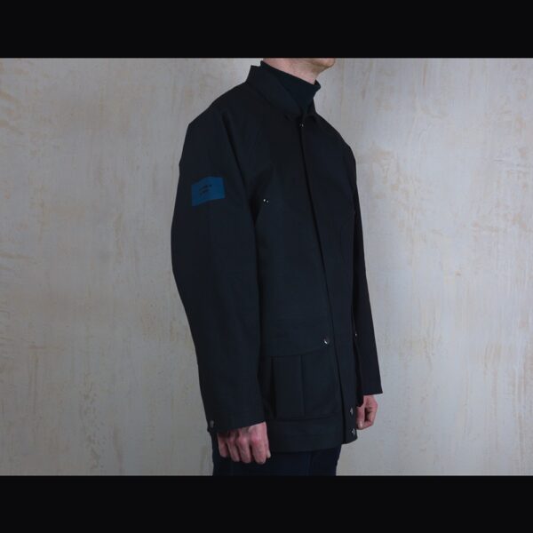 Logo-Side-View-Of-Model-Wearing-Waterproof-Houndstooth-Print-Rain-Jacket-By-Rainford-Apparel