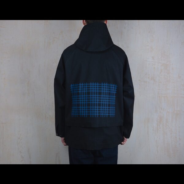 Back-View-Of-Model-Wearing-Waterproof-Houndstooth-Print-Rain-Jacket-By-Rainford-Apparel