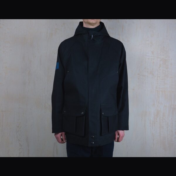 Front-View-Of-Model-Wearing-Waterproof-Houndstooth-Print-Rain-Parka-By-Rainford-Apparel