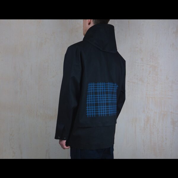 Back-View-Of-Model-Wearing-Waterproof-Houndstooth-Print-Rain-Parka-By-Rainford-Apparel