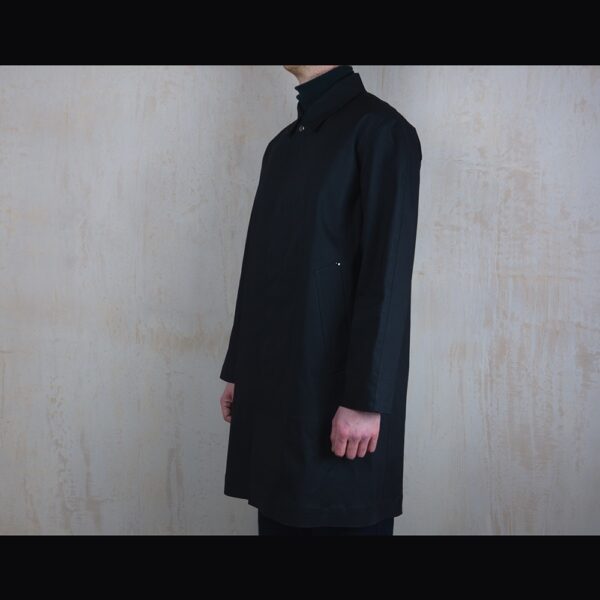 Side-View-Of-Model-Wearing-Waterproof-Black-Reinford-Raincoat-By-Rainford-Apparel